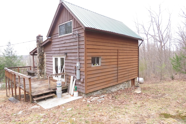 exterior space with french doors, metal roof, and a wooden deck