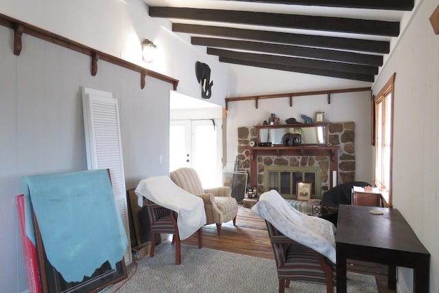 living room with vaulted ceiling with beams and a fireplace