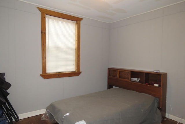 bedroom featuring baseboards and dark wood-type flooring