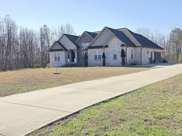 view of front of property with driveway, a front yard, a garage, and roof with shingles