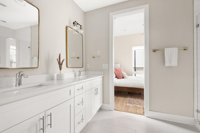 ensuite bathroom with a tile shower, double vanity, a sink, and visible vents