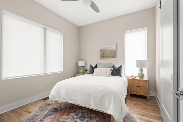 bedroom featuring visible vents, baseboards, light wood finished floors, and a ceiling fan