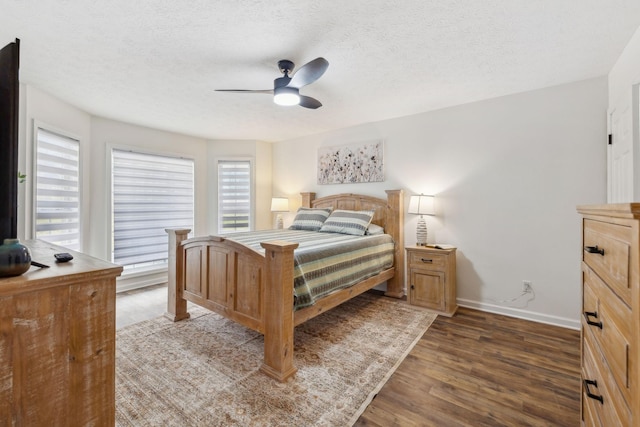 bedroom with baseboards, a ceiling fan, wood finished floors, and a textured ceiling