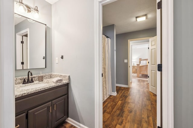 bathroom featuring vanity, baseboards, and wood finished floors