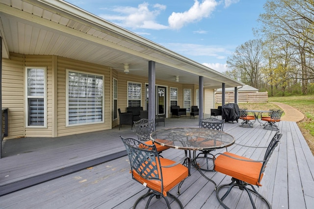 wooden deck featuring outdoor dining space and ceiling fan