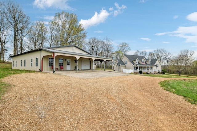 view of front of property featuring a carport, covered porch, an attached garage, and dirt driveway