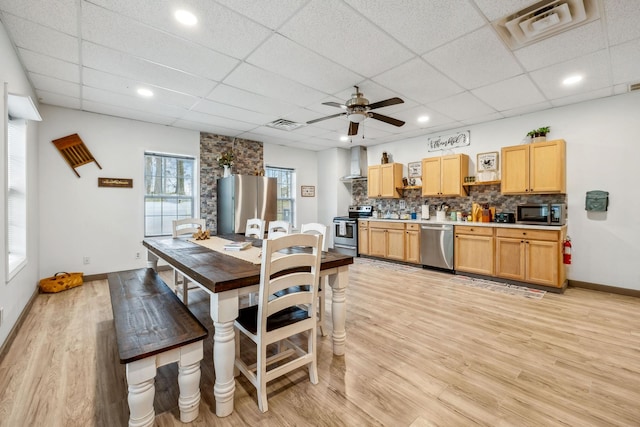dining area with visible vents, baseboards, ceiling fan, a drop ceiling, and light wood-style floors