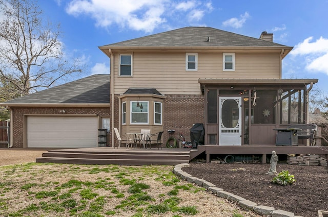 exterior space with a wooden deck, a sunroom, a garage, brick siding, and a chimney