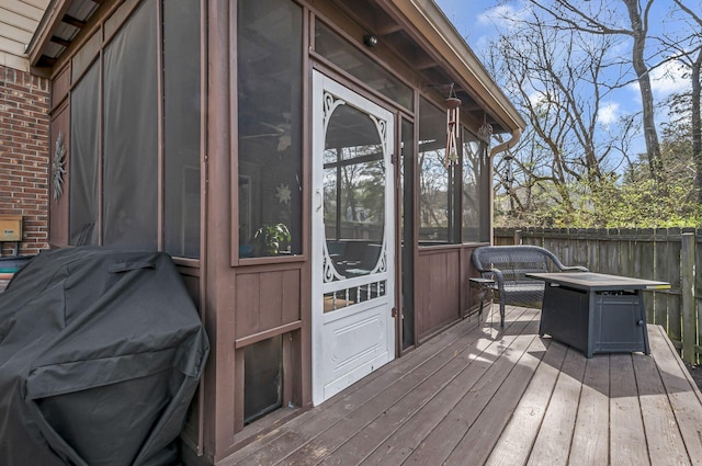 deck with fence and a sunroom