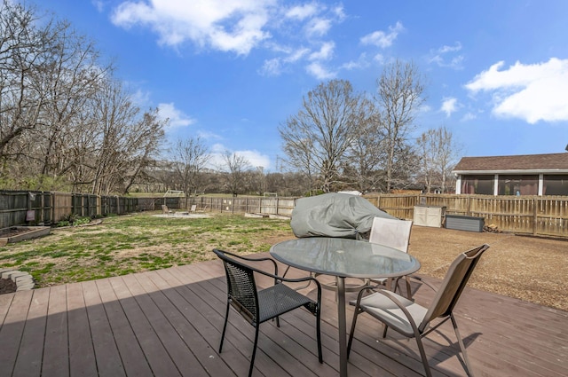 wooden terrace with outdoor dining area and a fenced backyard