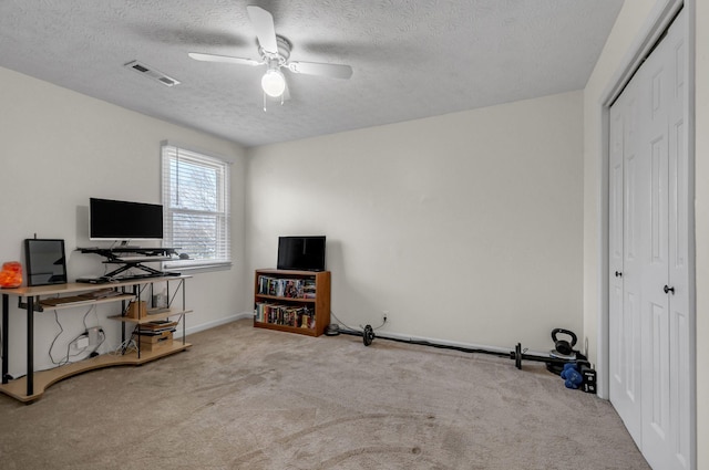 misc room featuring visible vents, a textured ceiling, a ceiling fan, and carpet