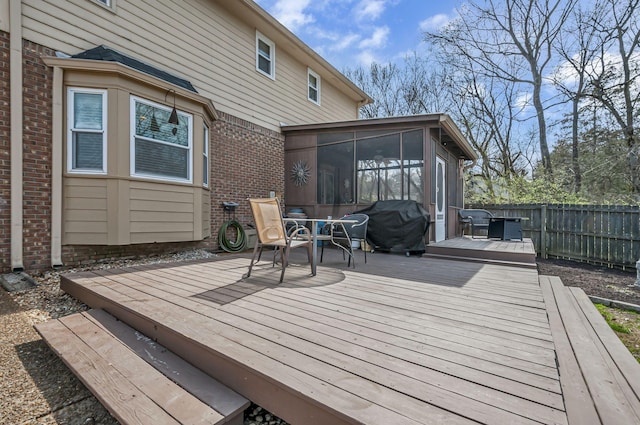 deck with fence, a grill, and a sunroom