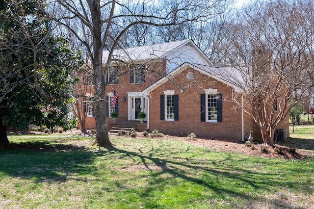 view of front of house featuring brick siding and a front yard