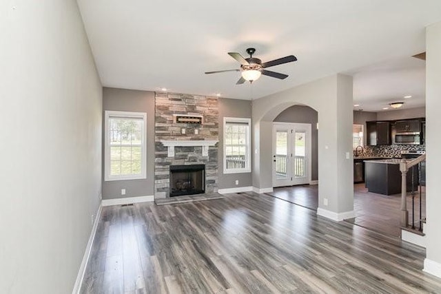1033 Garner Hills Dr, Clarksville, TN 37042 - unfurnished living room featuring arched walkways, baseboards, ceiling fan, and wood finished floors