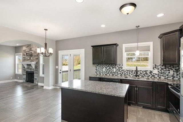1033 Garner Hills Dr, Clarksville, TN 37042 - kitchen with open floor plan, light stone counters, decorative backsplash, stainless steel range with electric cooktop, and a sink