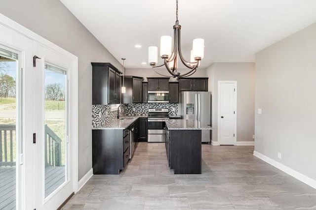 1033 Garner Hills Dr, Clarksville, TN 37042 - kitchen with a sink, a kitchen island, stainless steel appliances, an inviting chandelier, and decorative backsplash