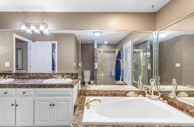 bathroom with a bath, double vanity, a sink, a shower stall, and toilet