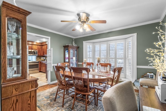 dining area with ornamental molding, a ceiling fan, and light wood finished floors
