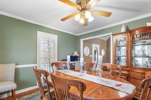 dining area with baseboards, wood finished floors, ceiling fan, and ornamental molding