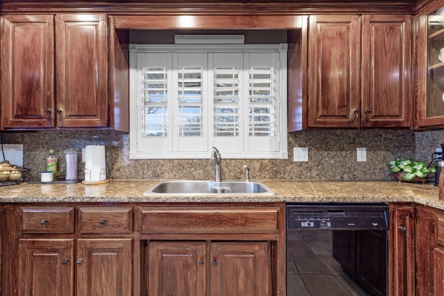 kitchen featuring decorative backsplash, tile patterned floors, black dishwasher, and a sink