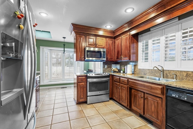kitchen featuring tasteful backsplash, light tile patterned floors, light stone counters, stainless steel appliances, and a sink