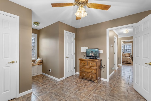 corridor with tile patterned floors, baseboards, and ornamental molding