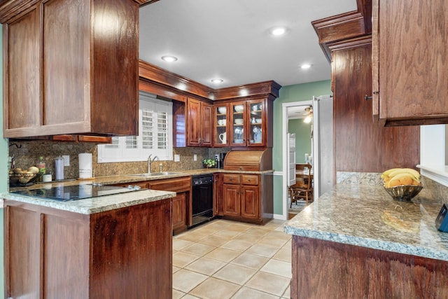 kitchen featuring black appliances, a sink, light tile patterned floors, decorative backsplash, and light stone countertops