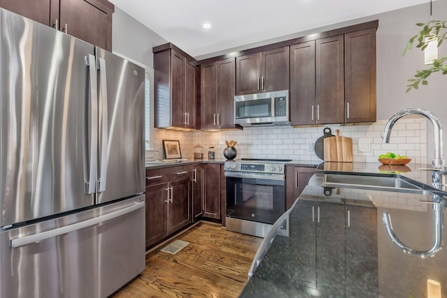 2003 Convent Pl Unit 6, Nashville, TN 37212 - kitchen with appliances with stainless steel finishes, dark wood-type flooring, dark stone countertops, backsplash, and recessed lighting