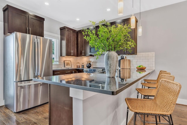2003 Convent Pl Unit 6, Nashville, TN 37212 - kitchen with freestanding refrigerator, dark brown cabinetry, dark wood-type flooring, tasteful backsplash, and a breakfast bar