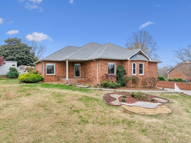 view of front of house featuring brick siding, a shingled roof, and a front lawn