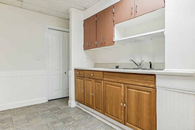 kitchen featuring a sink, wainscoting, light countertops, and open shelves