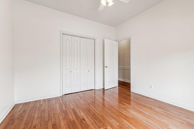 unfurnished bedroom featuring light wood-style flooring, baseboards, a closet, and ceiling fan