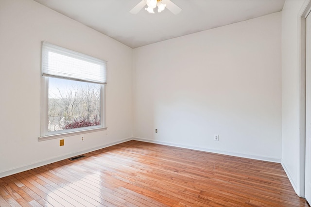 unfurnished room featuring light wood-style flooring, baseboards, visible vents, and ceiling fan