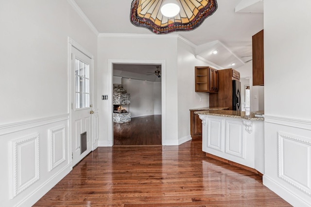 interior space featuring crown molding, baseboards, dark wood-style flooring, and vaulted ceiling