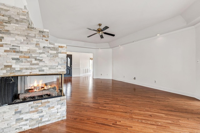 unfurnished living room with a fireplace, baseboards, ceiling fan, and wood finished floors
