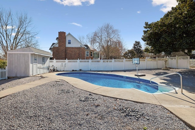 view of swimming pool featuring an outbuilding, a fenced backyard, a fenced in pool, and a patio area
