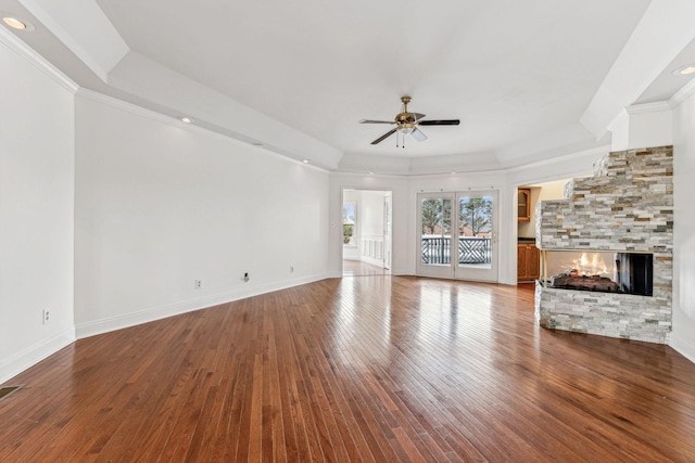 unfurnished living room featuring baseboards, ornamental molding, a fireplace, a ceiling fan, and wood-type flooring
