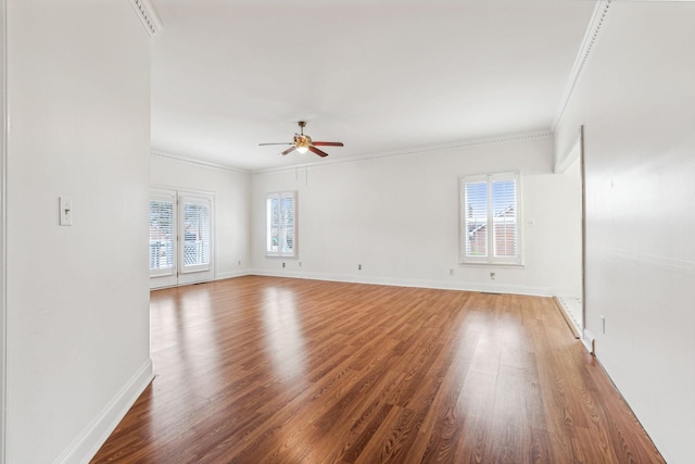 empty room with wood finished floors, a wealth of natural light, and ceiling fan