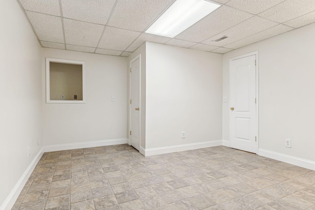 unfurnished room with a drop ceiling, visible vents, and baseboards