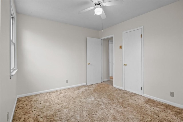 unfurnished bedroom with a ceiling fan, carpet, and baseboards