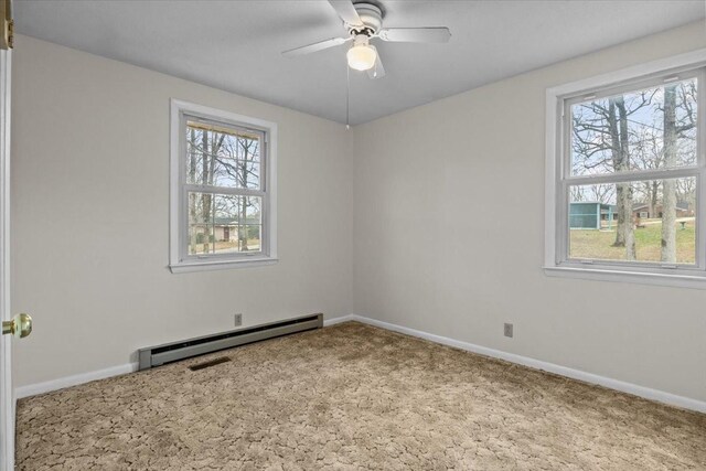 carpeted spare room featuring a wealth of natural light, a baseboard radiator, and baseboards