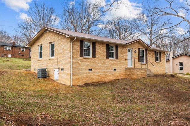 view of front of property with brick siding, a front yard, cooling unit, metal roof, and crawl space