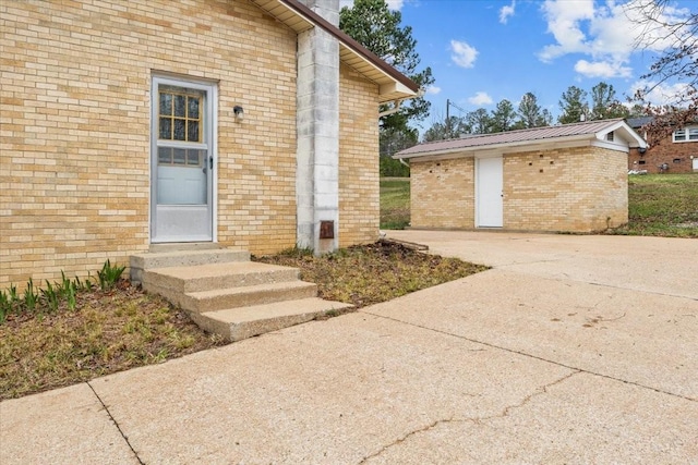 property entrance featuring brick siding and metal roof