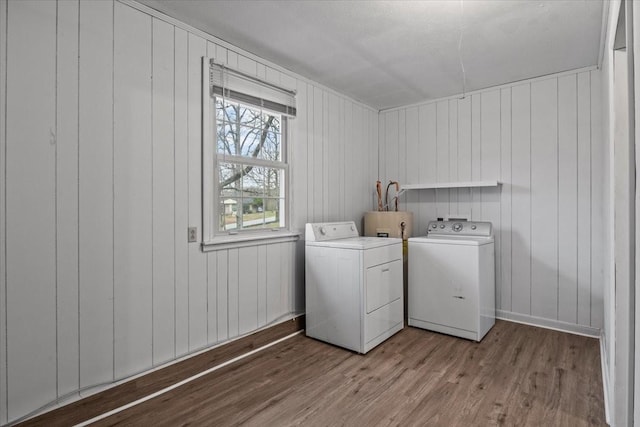 laundry area with laundry area, wood finished floors, and washing machine and dryer