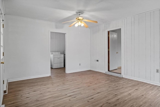 empty room with washer and clothes dryer, baseboards, ceiling fan, and wood finished floors