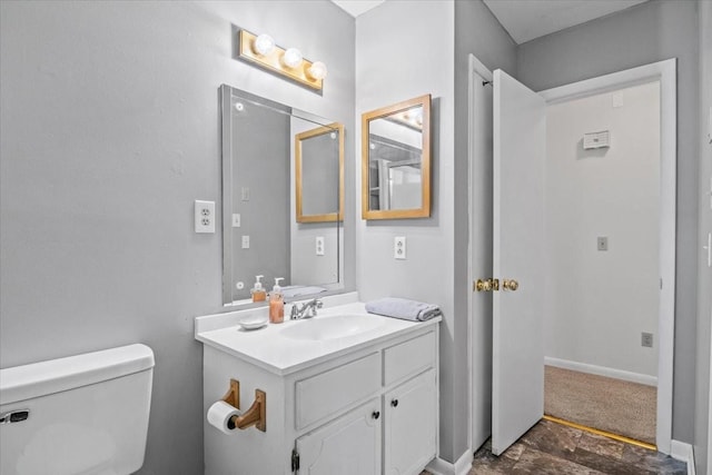 half bath with vanity, toilet, and baseboards