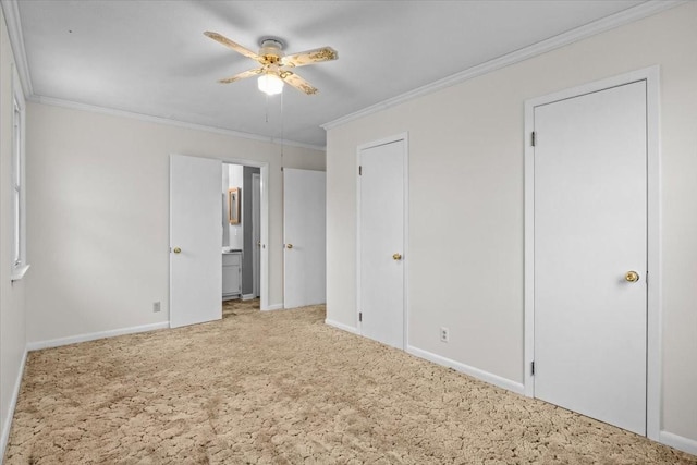 unfurnished bedroom with crown molding, carpet flooring, baseboards, and connected bathroom