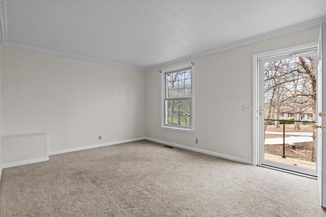 carpeted empty room featuring visible vents, baseboards, and crown molding