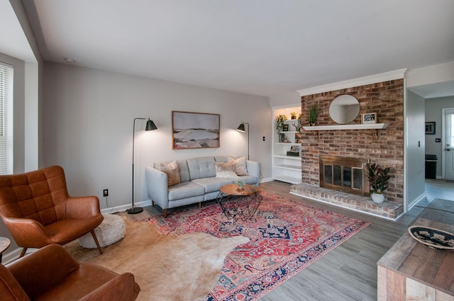 living area featuring a fireplace, baseboards, and wood finished floors