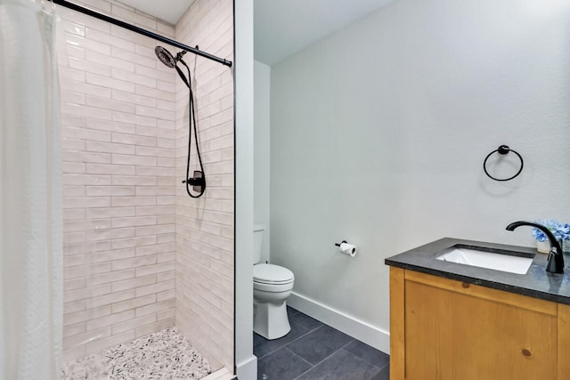 full bathroom featuring vanity, baseboards, a stall shower, tile patterned flooring, and toilet